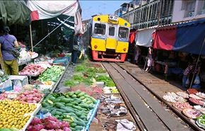 قطار يمر وسط سوق للفاكهة