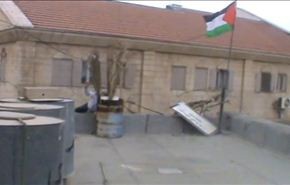 بالفيديو.. مستوطن يحاول إزالة علم فلسطين من على منزل والجیش یدعمه