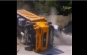 رجل ينجو بعد سقوط شاحنة على سيارته...فيديو