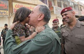 بالصور؛ قبلة من وزير دفاع العراق على خد طفلة في بيجي