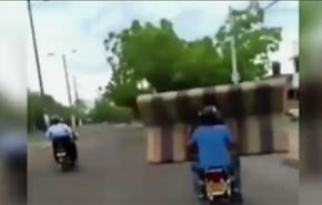 بالفيديو.. نقل اريكة بين رجلين على دراجة نارية