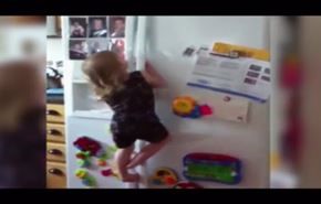 فيديو... طفلة تتسلق ثلاجة للحصول على الحلوى