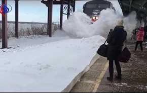 بالتصوير البطيء.. قطارٌ يغطي الركاب المنتظرين على رصيف المحطة بالثلج