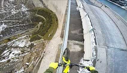 دوچرخه سواری روی نرده های یک سد در ارتفاع 198 متری + ویدیو