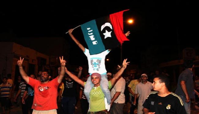 ليبيون بصدد انزال العلم الأخضر من سفارة بلادهم بالقاهرة 