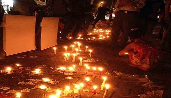 بالصور؛ العراقيون يشعلون الشموع بدموعهم في موقع تفجير الكرادة