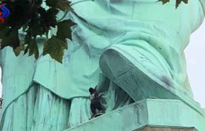 امرأة تتسلق تمثال الحرية للإحتجاج على سياسة ترامب + فيديو