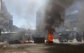 محتجون يمنيون يمزقون صورا لهادي والملك سلمان في تعز