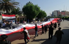الكربلائيون يرفعون أكبر علم عراقي تعبيراً عن السلمية