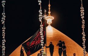 تصاویری از برافراشته شدن پرچم سیاه بر گنبد امام علی (ع)