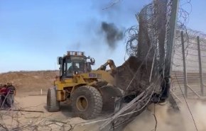 بولدوزر فلسطینی در حال برچیدن دیوار حائل سیم خاردار در مرز غزه+ویدیو