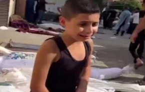 طفل ناج من الغارات الصهيونية يبحث عن ذويه بين الجثامين! + فيديو
