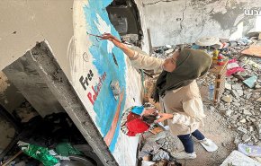 فلسطينية تجسد معاناة شعبها برسم لوحات على ركام المنازل المدمرة