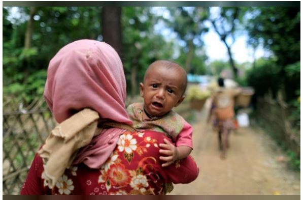 لاجئة روهنغية تحمل طفلها في بنغلايش