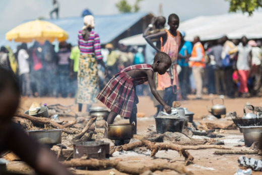 بنت لاجئة من جنوب السودان تطبخ الطعام في معسكر بأوغندا