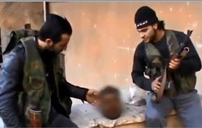 فيديو/مسلحان يتلاعبان برأس جندي سوري بعد ذبحه ويسخران منه