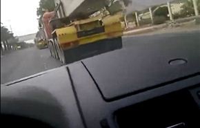 بالفيديو.. سعودي يعبر بسيارته تحت شاحنتين محملتين بصبات بناء