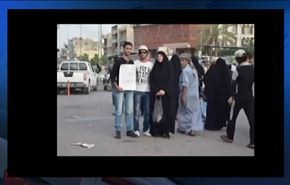 بالفيديو/شاب عراقي يحمل لافتة تجذب زوار الكاظمية لتحيته، فماذا كتب؟