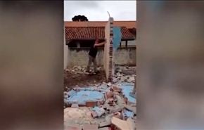بالفيديو.. عامل يهدم حائطا ويسقط الثاني فوق رأسه