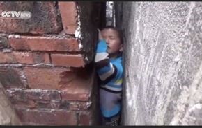 شاهد... طفل مشاغب يحشر نفسه بين جدارين