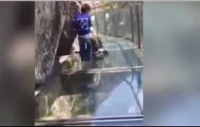 فيديو طريف.. الأب يجلس مرعوباً وطفله يجره على جسر زجاجي بالصين