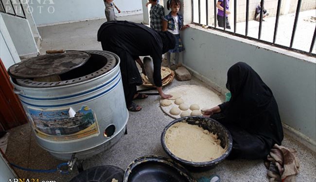 عکس خبری/ پخت نان توسط دو بانوی آواره یمنی