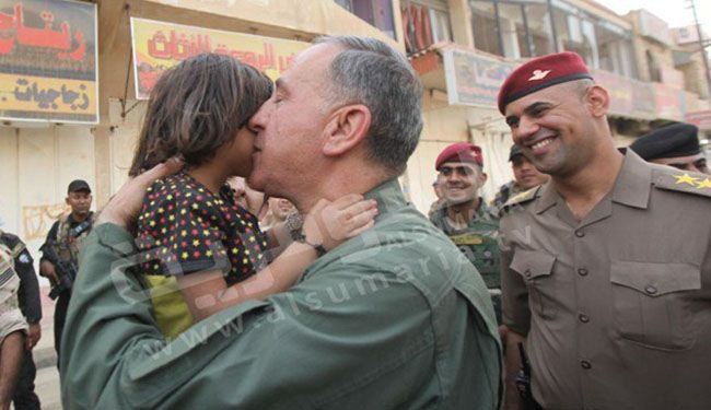 بالصور؛ قبلة من وزير دفاع العراق على خد طفلة في بيجي
