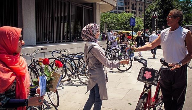 بالصور.. مسلمات أميرکيات يهدين الورود إلی المارة