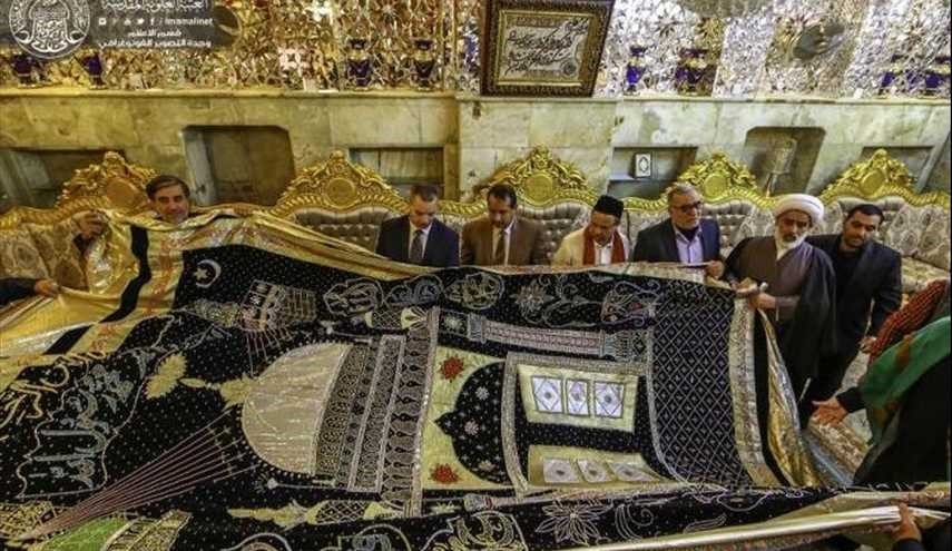 بالصور..مغتربون في بريطانيا يقدمون بردة ثمينة مرصعة بالأحجار الثمينة لمرقد أمير المؤمنين (ع) بالنجف الاشرف