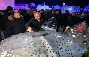 بوتين يغرز قطعة نقدية على ظهر خنزير من الجليد ويضمر أمنية
