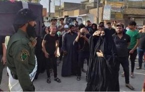 بالصورة.. أم شهيد عراقي تستقبل جنازة إبنها بالتحية العسكرية