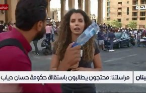 بالفيديو.. محتجون لبنانيون يمنعون مراسلة قناة اميركية من اكمال تغطيتها
