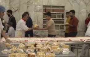 بالفيديو.. توزيع أكبر كعكة في العالم في مرقد أمير المؤمنين (ع)