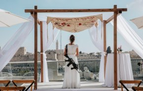 شاهد.. عروس إسرائيلية تحمل بندقيتها حتى في يوم زفافها!