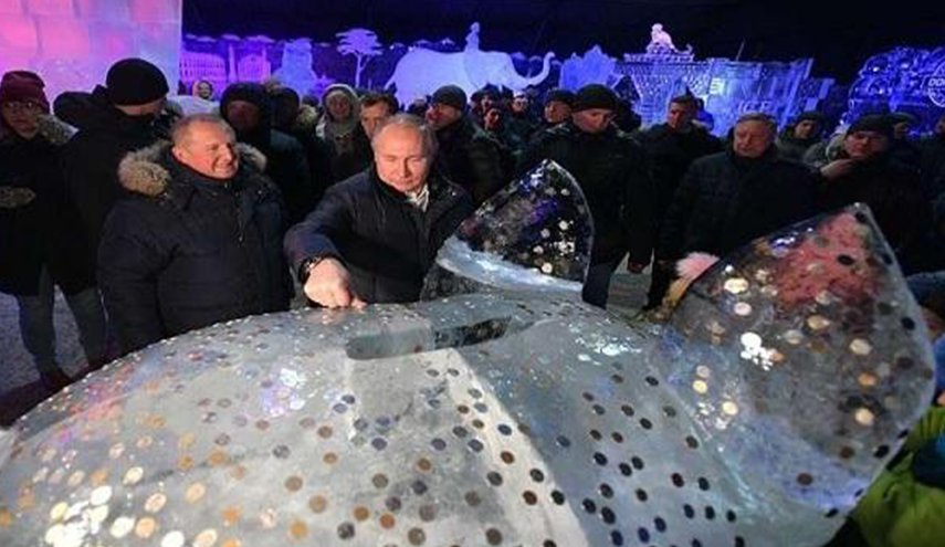 بوتين يغرز قطعة نقدية على ظهر خنزير من الجليد ويضمر أمنية