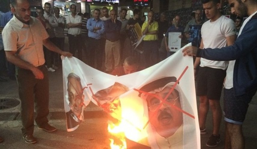 بالصور: متظاهرون بجنوب الضفة يحرقون صور ملك البحرين