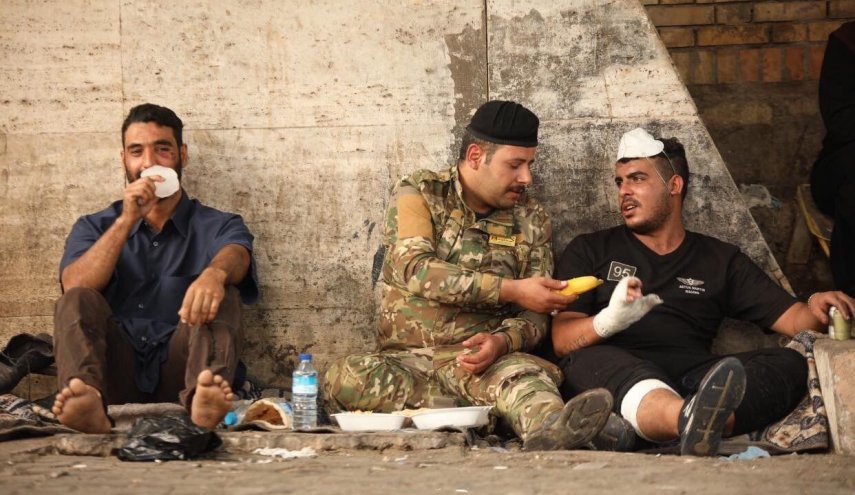 شاهد... صورة متظاهر وجندي عراقي تشعل المواقع
