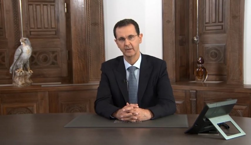 ما سر زجاجة ظهرت خلف الرئيس الأسد في خطابه الأخير؟