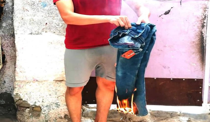 شاب عراقي يحرق ملابسه التركية في اولى خطوات مقاطعة البضائع التركية