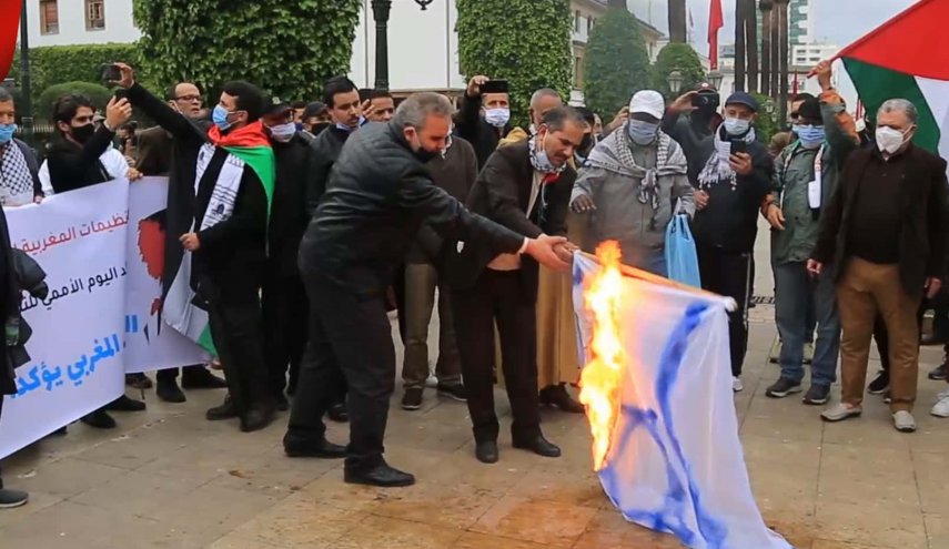 نشطاء مغاربة يحرقون علم الإحتلال الإسرائيلي تضامنا مع الفلسطينيين