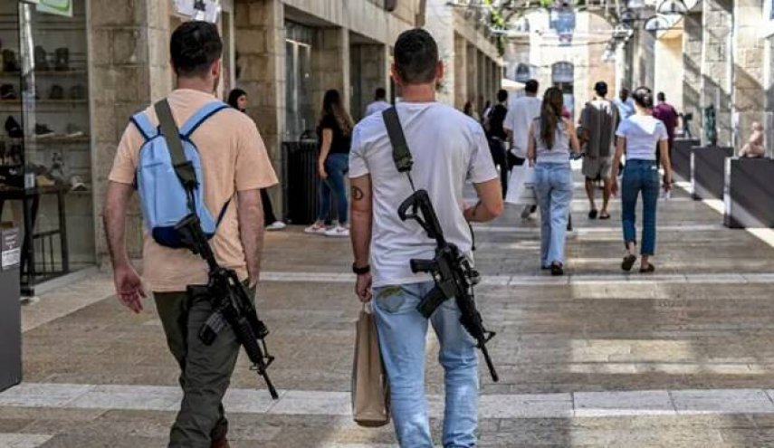 حضور مجری‌ شبکه اسرائیلی با اسلحه در برنامه زنده/ بن‌گویر خبرنگاران صهیونیست را مسلح کرد + عکس