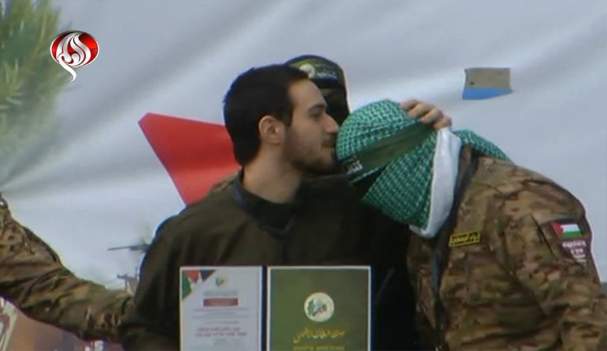 خلال تسليم الأسرى.. تقبيل رأس مقاتلي القسام وتنكيس السلاح