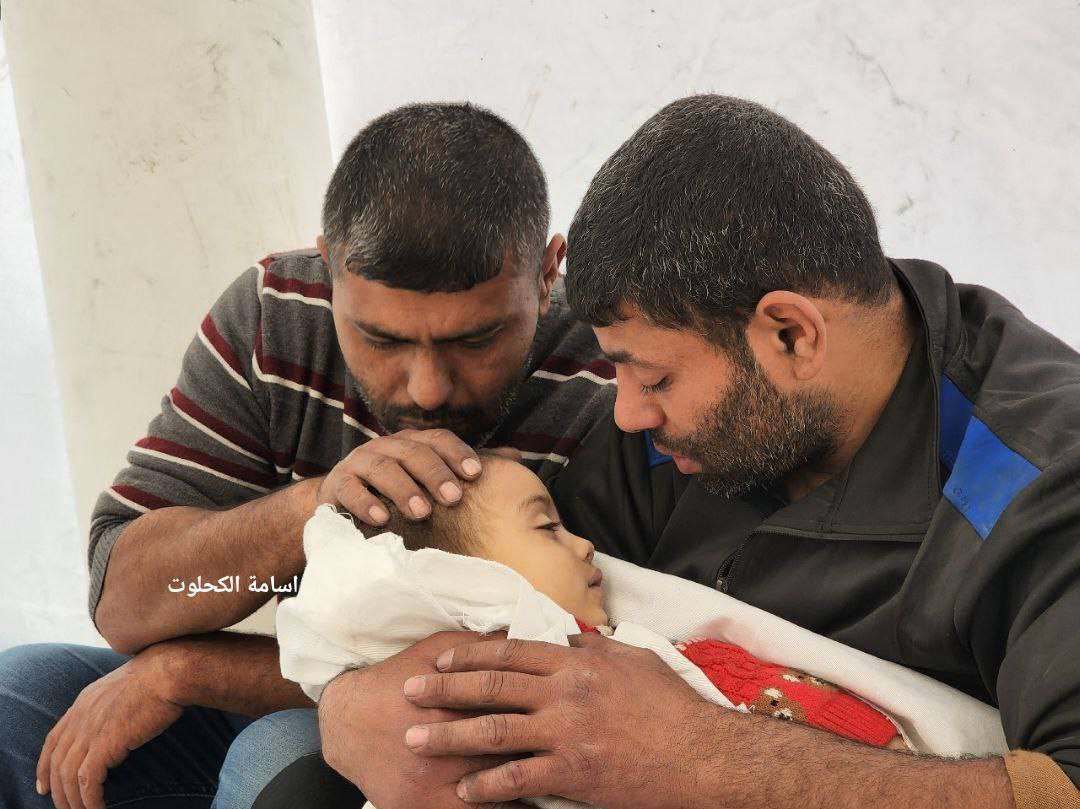 فلسطيني يلقي نظرة الوداع الأخيرة على طفلته التي قتلها جيش الاحتلال في غاراته على قطاع غزة