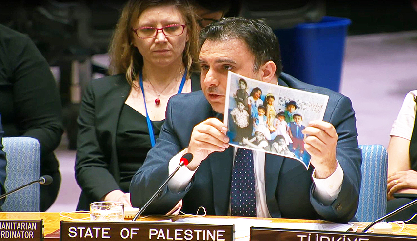 الصورة: السفير ماجد بامية يعرض صورا لأطفال استشهدوا خلال العدوان الإسرائيلي المتواصل على قطاع غزة